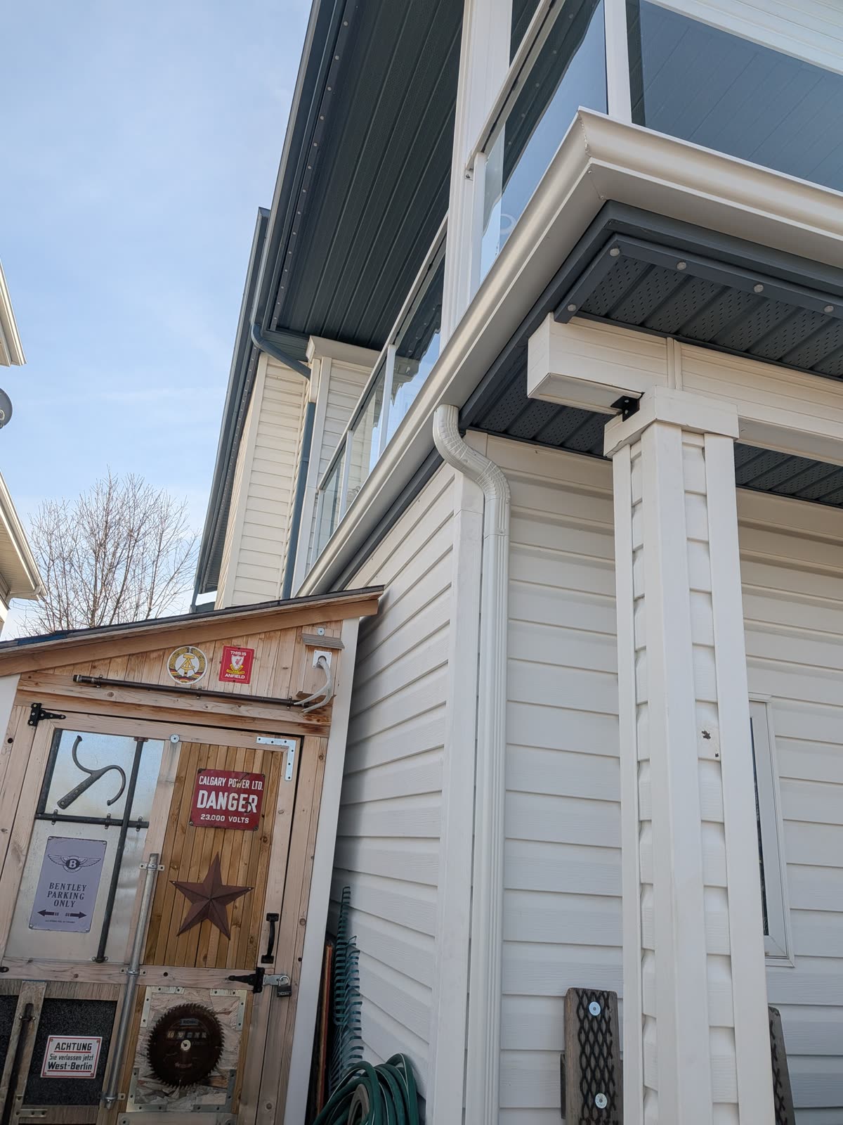 New gutter and downspout installed on modern home with deck