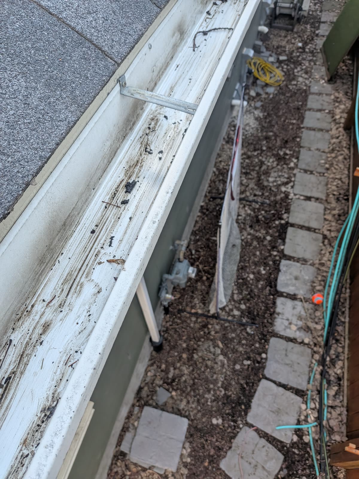 Debris being removed from clogged gutter