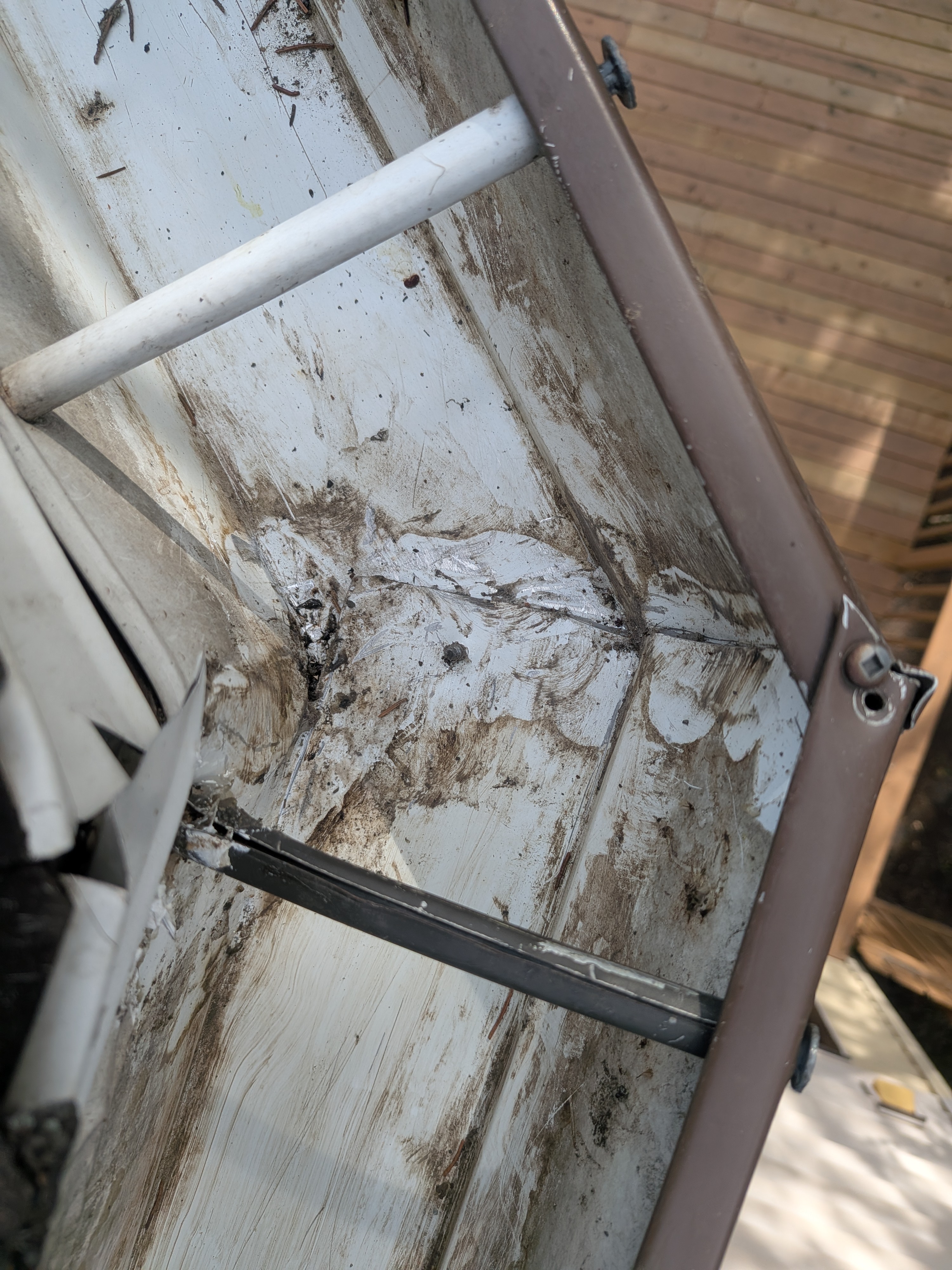 Gutter seam resealing in progress on home exterior